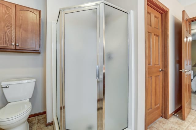 bathroom featuring tile patterned flooring, an enclosed shower, and toilet