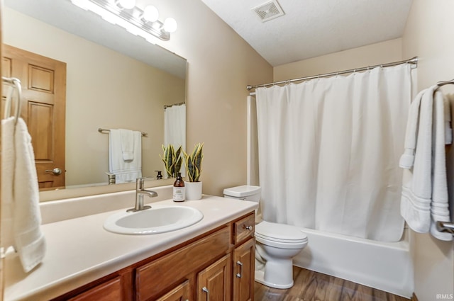 full bathroom with vanity, hardwood / wood-style floors, shower / bath combo with shower curtain, and toilet