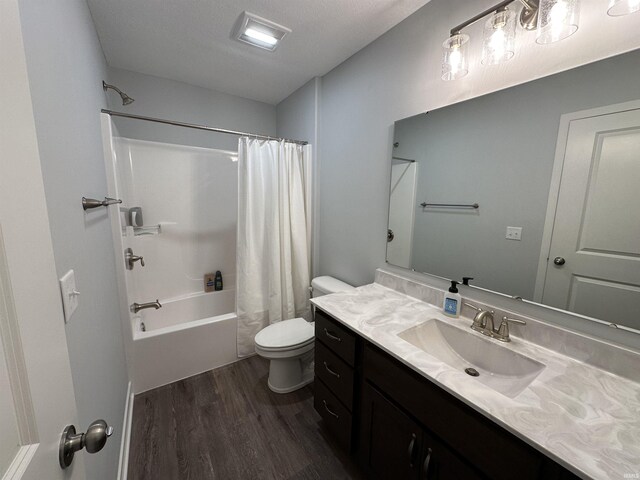 full bathroom featuring hardwood / wood-style flooring, vanity, shower / bath combo with shower curtain, and toilet