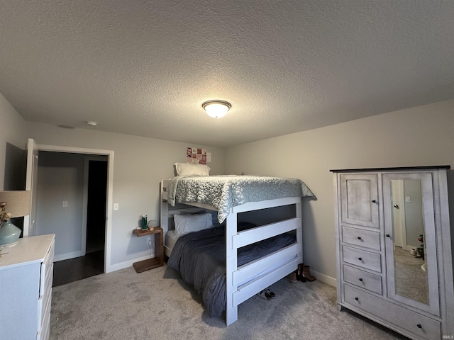 bedroom with light colored carpet and a textured ceiling