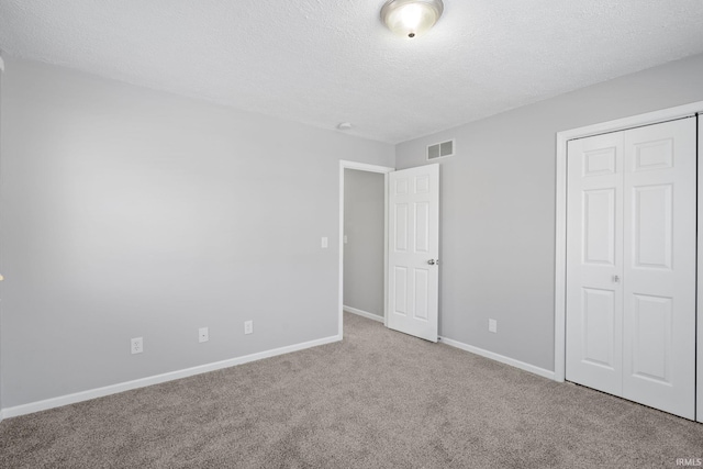 unfurnished bedroom with a closet, a textured ceiling, and carpet