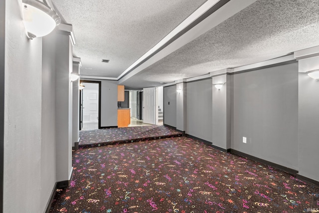 hall with carpet flooring and a textured ceiling