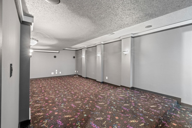 spare room with dark carpet and a textured ceiling