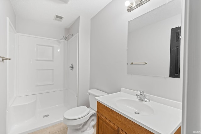 bathroom featuring a shower, vanity, a textured ceiling, and toilet