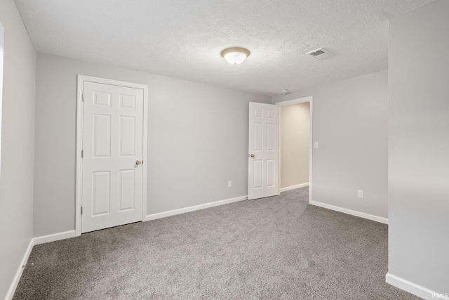 carpeted empty room with a textured ceiling