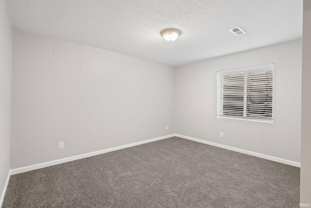 empty room with carpet floors and a textured ceiling