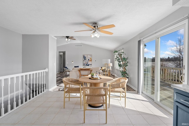 tiled dining area with lofted ceiling and a textured ceiling