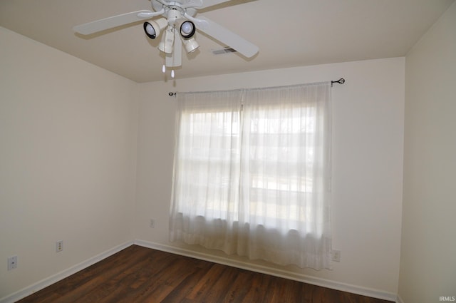 spare room with ceiling fan, wood finished floors, visible vents, and baseboards