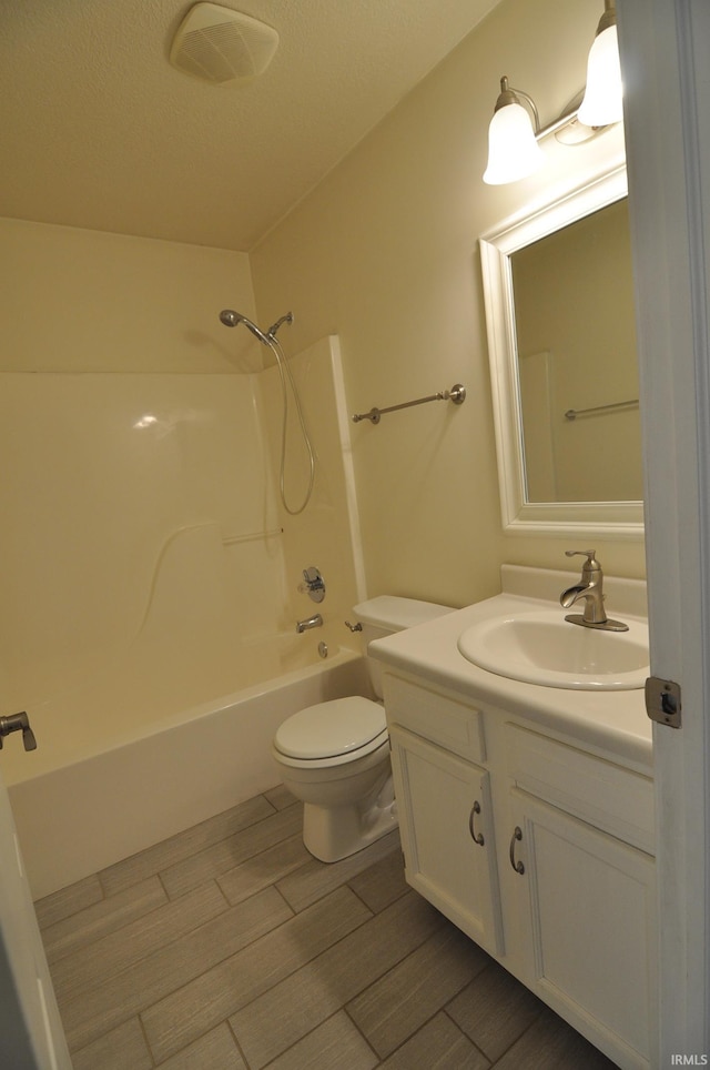 bathroom with toilet, wood finish floors, visible vents, vanity, and shower / bathing tub combination