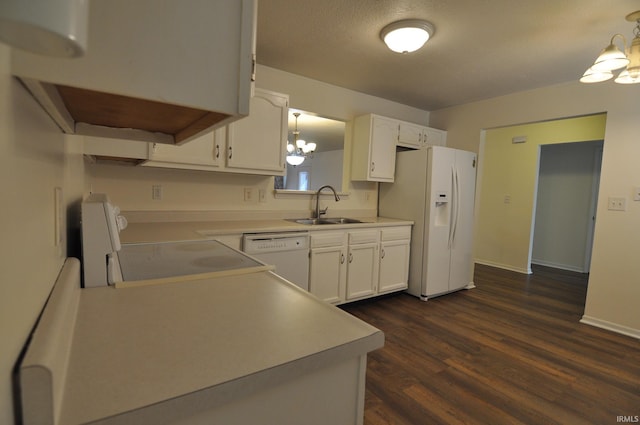 kitchen featuring sink, white appliances, white cabinetry, dark hardwood / wood-style flooring, and decorative light fixtures