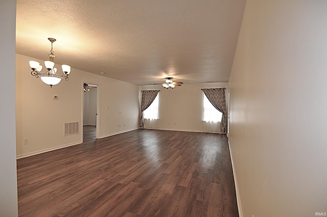 spare room featuring baseboards, visible vents, dark wood finished floors, a textured ceiling, and ceiling fan with notable chandelier