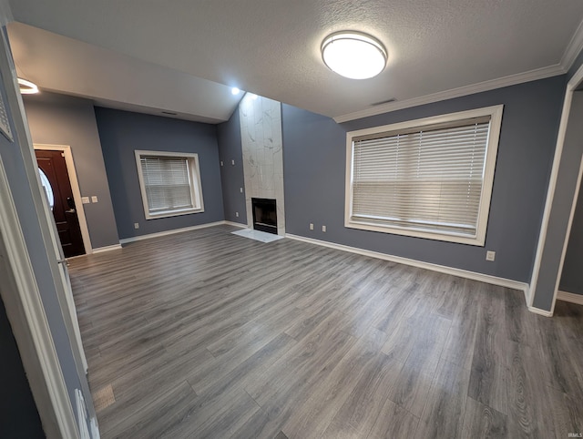 unfurnished living room featuring crown molding, dark hardwood / wood-style floors, a textured ceiling, and a fireplace