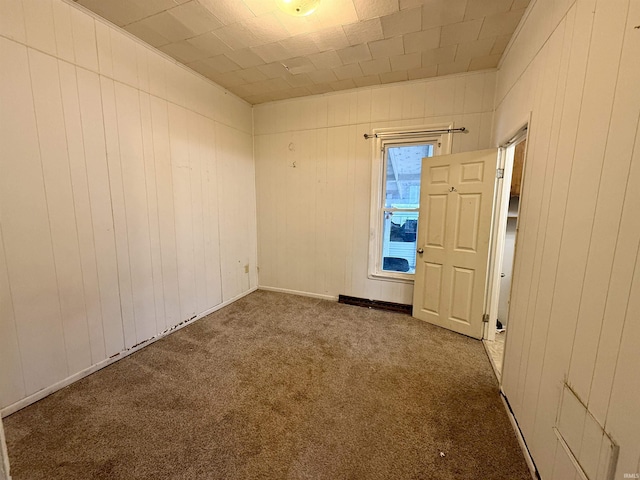 carpeted empty room with wooden walls