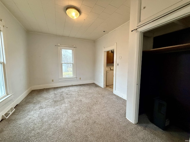 unfurnished bedroom featuring carpet floors, ornamental molding, and independent washer and dryer