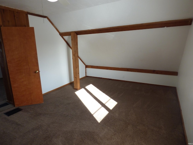 bonus room with lofted ceiling and dark colored carpet