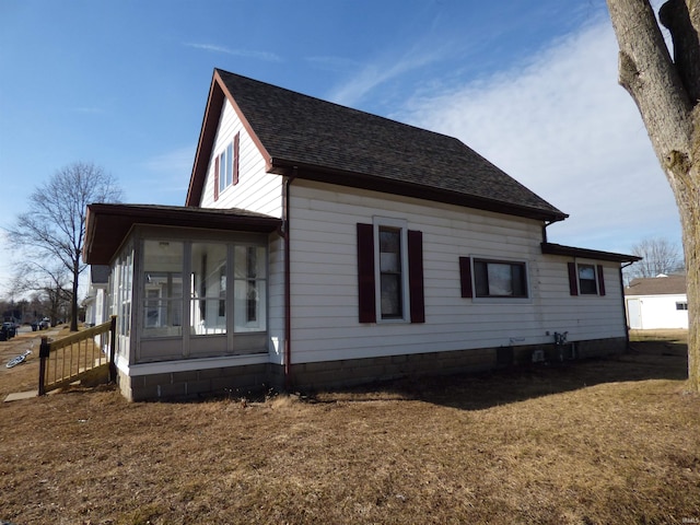 view of property exterior with a yard and a sunroom