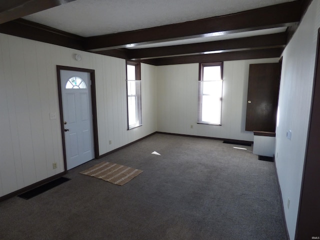 entryway featuring beamed ceiling and carpet flooring