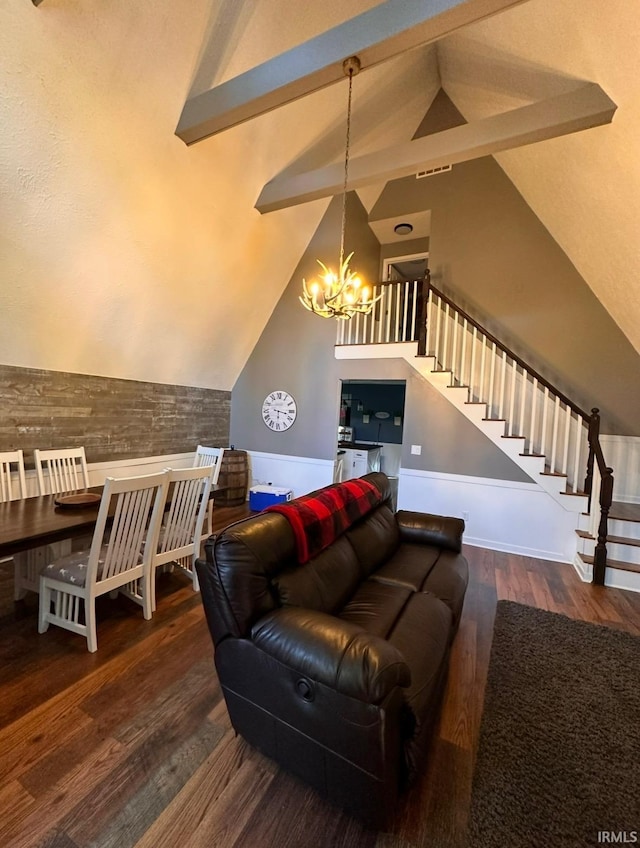 living room with a notable chandelier, dark wood-type flooring, and vaulted ceiling with beams