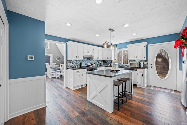 kitchen featuring a kitchen island, appliances with stainless steel finishes, and white cabinets