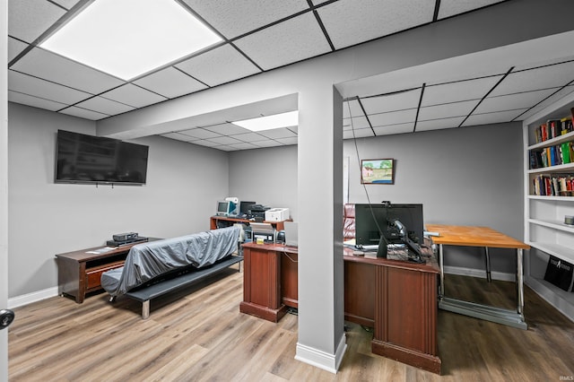 office with light hardwood / wood-style floors and a drop ceiling