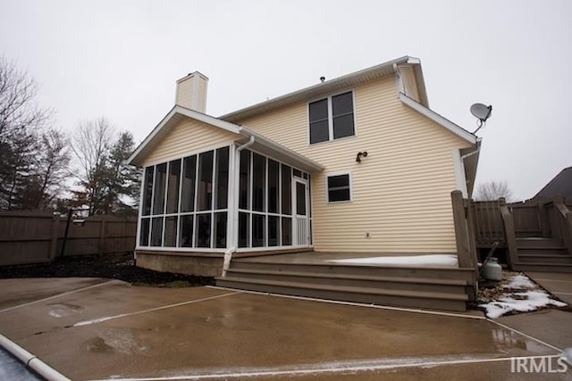 1222 S Donington Ct, Bloomington, IN 47401 - rear view of property with a sunroom, a chimney, a deck, and uncovered parking