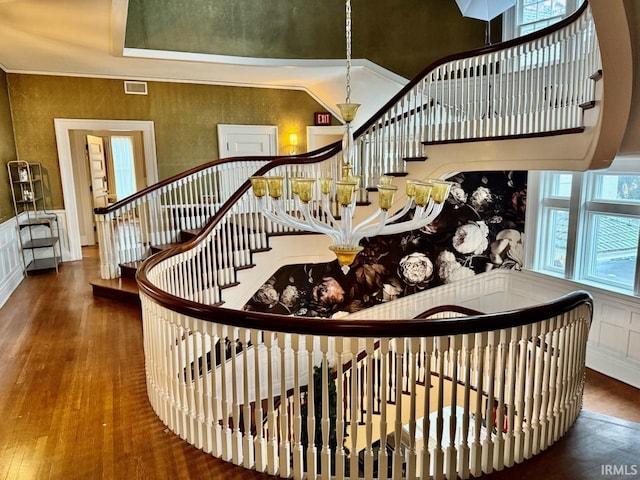 stairway with hardwood / wood-style flooring and ornamental molding