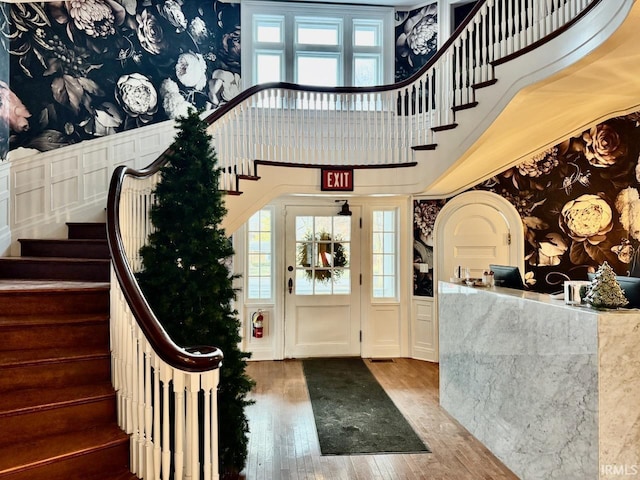 foyer featuring a towering ceiling and wood-type flooring