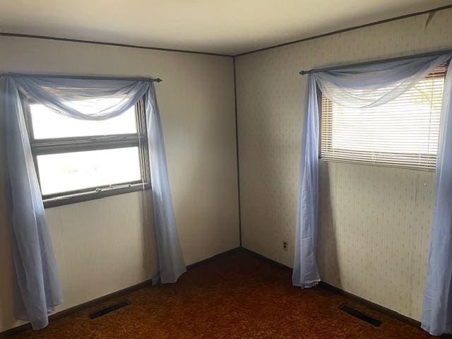 unfurnished room with dark carpet