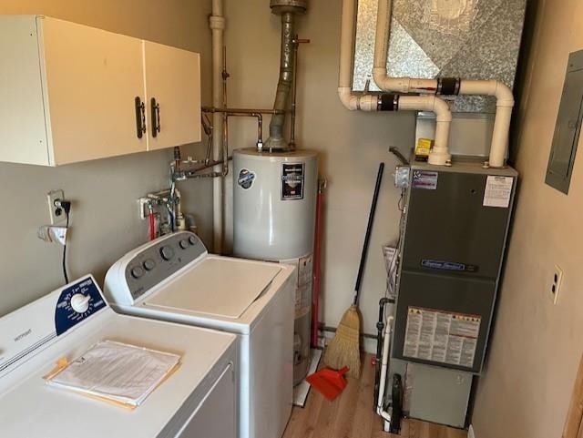 laundry room featuring hardwood / wood-style flooring, cabinets, separate washer and dryer, and gas water heater