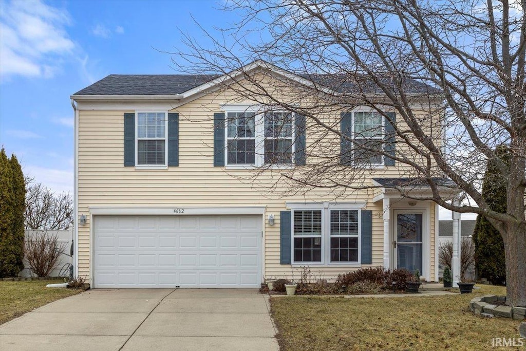 view of front of house with a garage and a front lawn