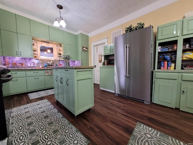 kitchen with dark wood-type flooring, high quality fridge, hanging light fixtures, and green cabinetry