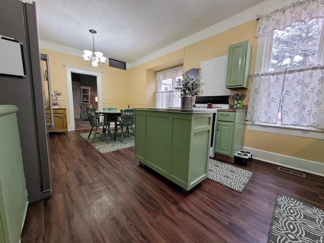 kitchen with pendant lighting, crown molding, green cabinetry, dark hardwood / wood-style flooring, and range with gas cooktop