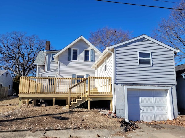 rear view of house with a garage and a deck