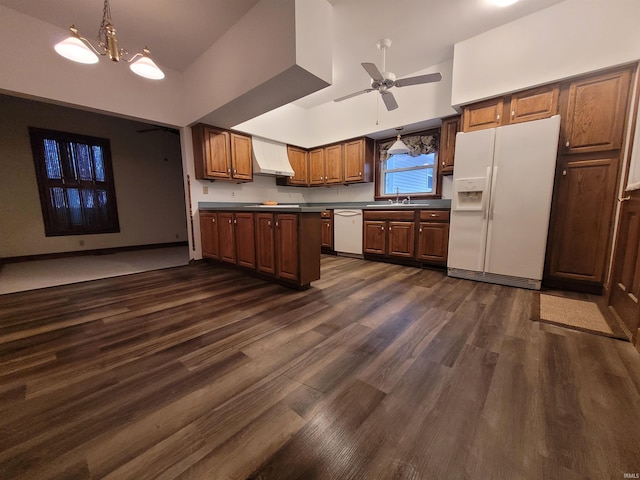 kitchen with decorative light fixtures, sink, dark wood-type flooring, white appliances, and wall chimney exhaust hood