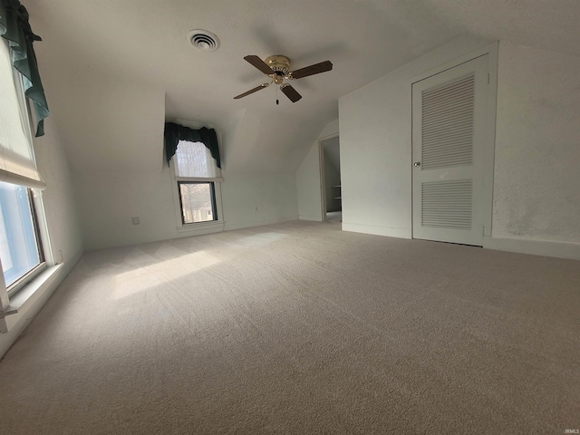 interior space with lofted ceiling, light colored carpet, and ceiling fan