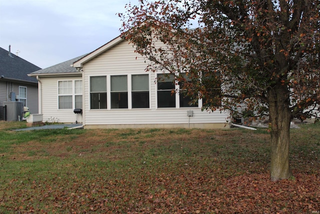 back of property featuring a yard and central air condition unit