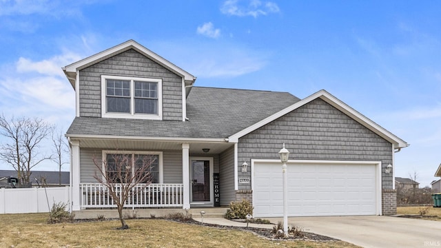 view of front of house featuring a porch, a garage, and a front lawn