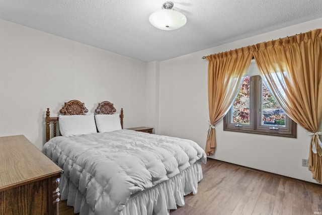 bedroom featuring hardwood / wood-style flooring and a textured ceiling