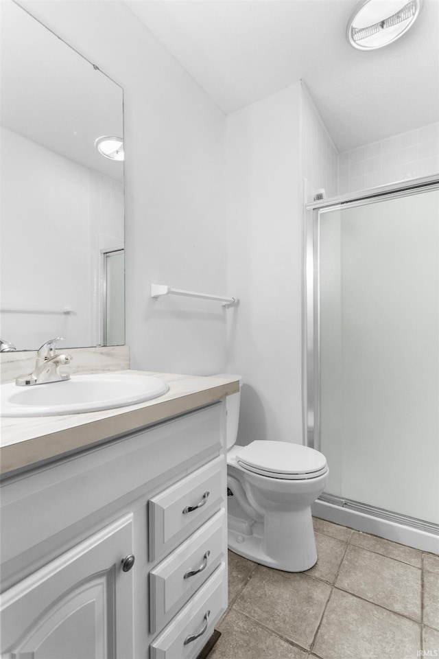 bathroom featuring vanity, a shower with shower door, and toilet