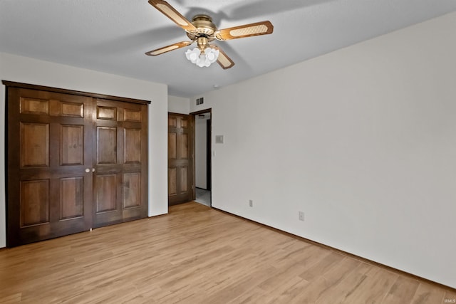 unfurnished bedroom with ceiling fan and light hardwood / wood-style flooring