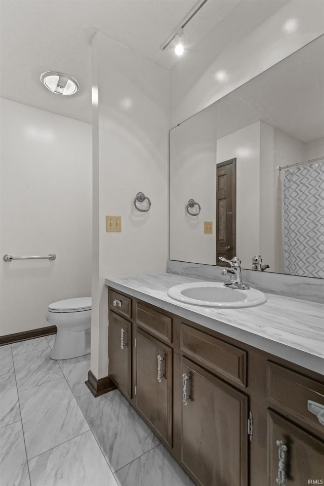 bathroom with walk in shower, vanity, and toilet