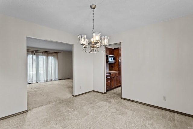 unfurnished dining area featuring an inviting chandelier