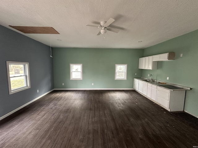 kitchen featuring dark wood-type flooring, sink, white cabinetry, a textured ceiling, and ceiling fan