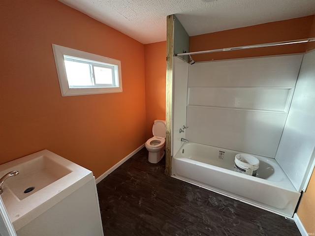 full bathroom featuring toilet, sink, a textured ceiling, shower / tub combination, and hardwood / wood-style flooring