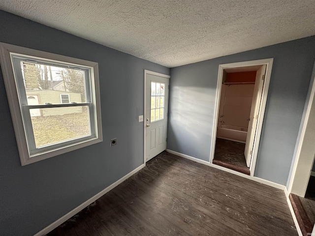 entryway with a textured ceiling and dark hardwood / wood-style flooring