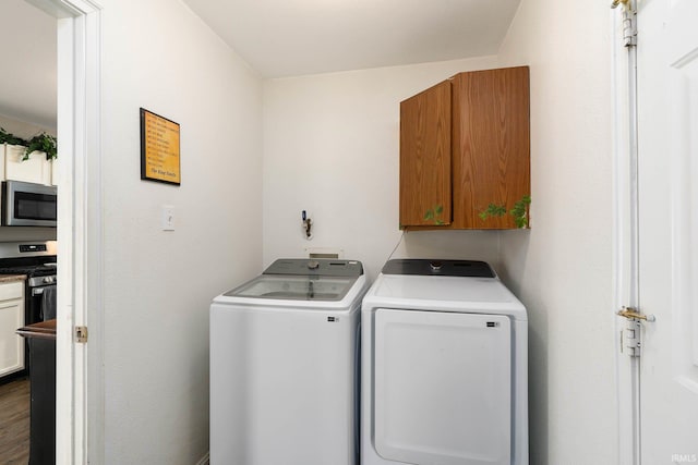 laundry area with cabinets and washing machine and clothes dryer