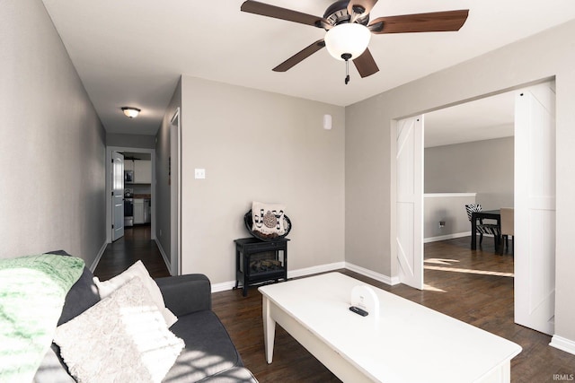 living room with dark wood-type flooring and ceiling fan