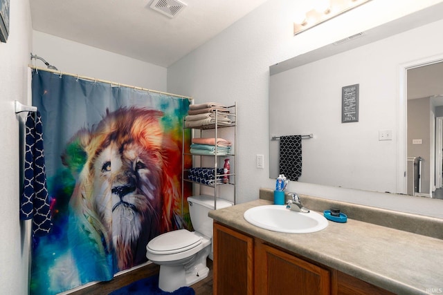 bathroom with vanity, walk in shower, and toilet