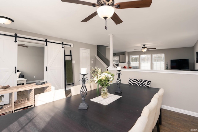 dining space with dark hardwood / wood-style floors, a barn door, and ceiling fan