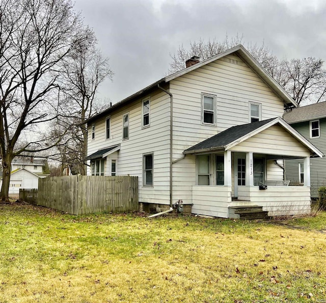 back of property with a yard and a porch